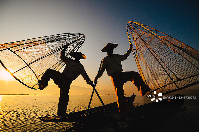 缅甸掸邦茵莱湖日出时分的茵达渔民，茵达渔民的传统腿划船方式图片素材