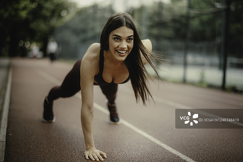 户外做俯卧撑的漂亮女人照片图片素材
