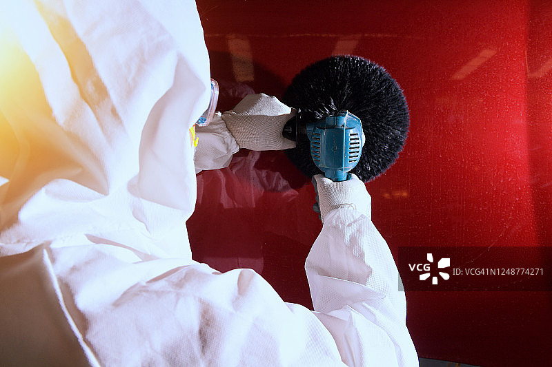 在泰国，一名机械师正在打磨汽车的背影图片素材