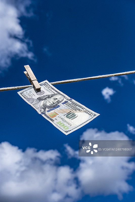 晾衣绳上晾晒的一百美元钞票图片素材