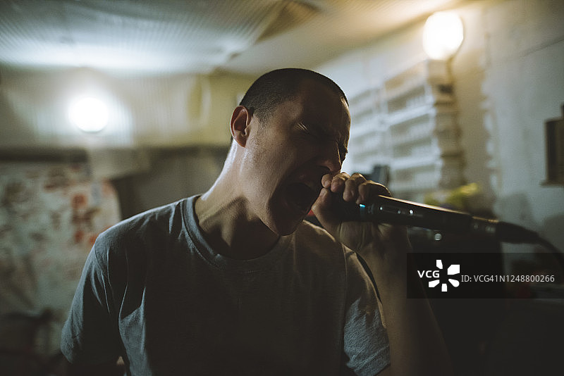 在车库的彩排中，年轻人正在唱歌图片素材