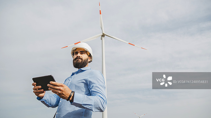 工程师使用数字无线平板电脑控制风车图片素材