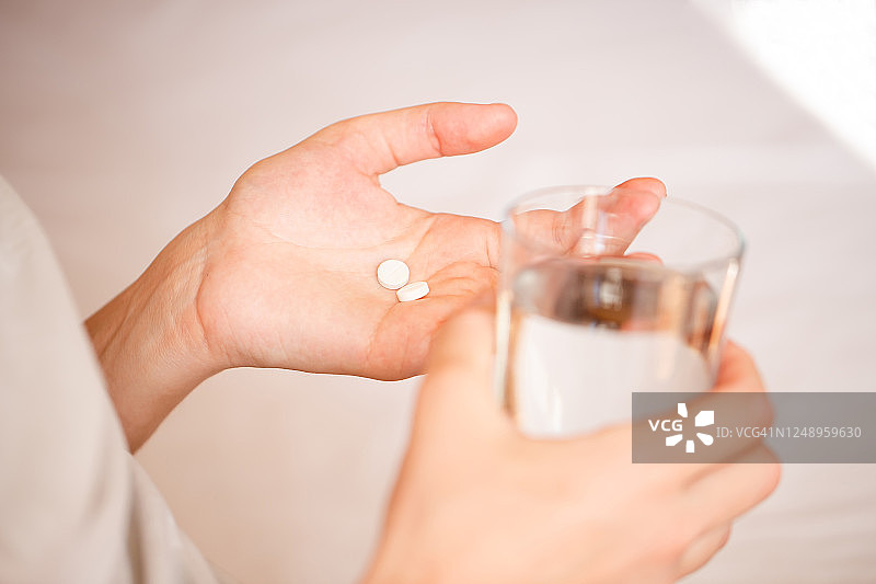 女性手中的白色药丸特写图片素材