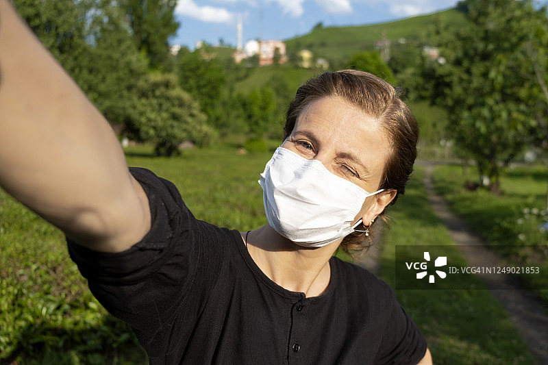 年轻女子戴着外科口罩自拍图片素材