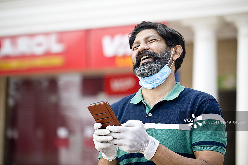 在疫情封锁后的城市中使用平板电脑的男人图片素材