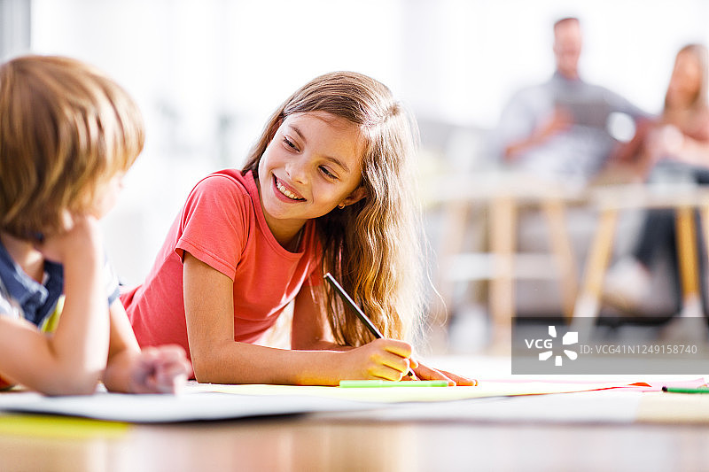 快乐的孩子在家在地板上画画聊天图片素材