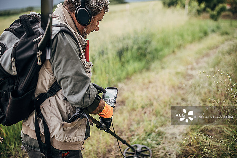 用金属探测器寻宝的男人图片素材