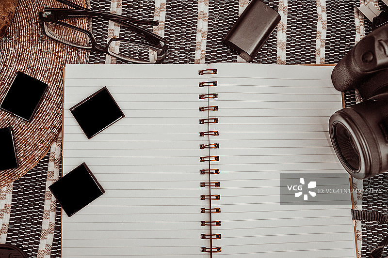 女性在开放笔记本上使用数码相机图片素材