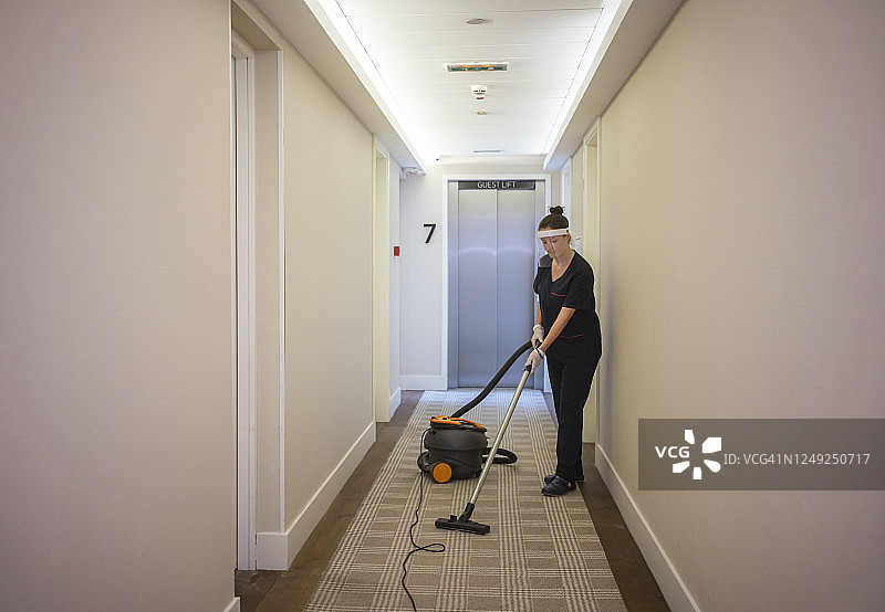 女佣在酒店工作时戴着口罩整理床铺图片素材