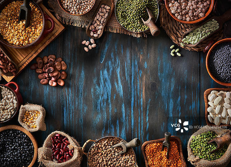 各种干豆在蓝色木桌上构成框架的俯视低调照片图片素材