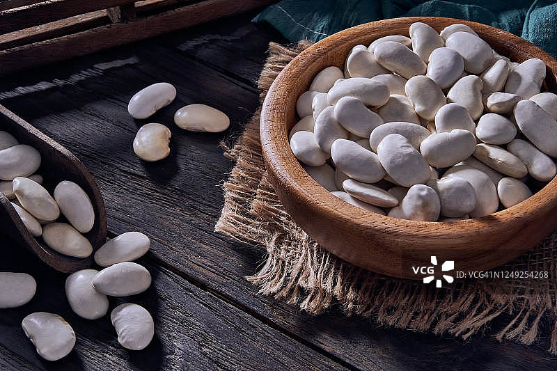 木桌上木罐中白豆的低调特写图片素材
