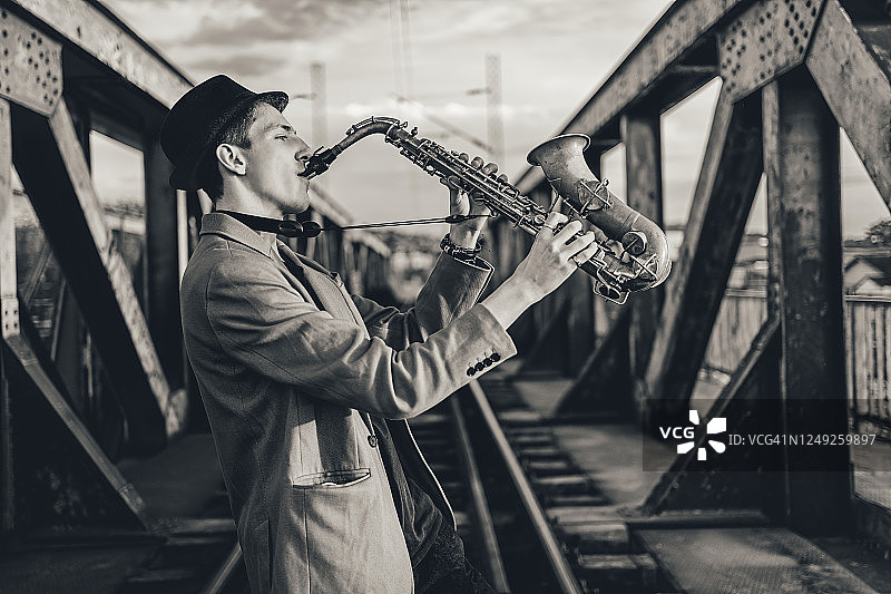 在铁路桥上吹萨克斯的男人图片素材