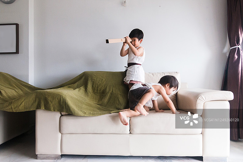 年轻男孩们在沙发上搭建帐篷玩耍图片素材
