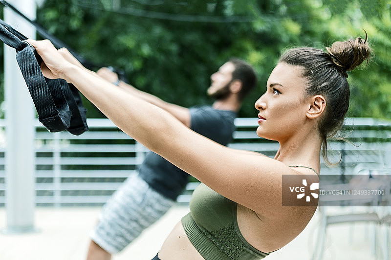 健身情侣在户外使用TRX带锻炼图片素材