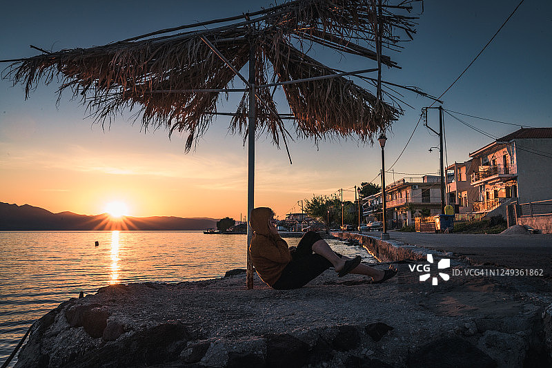 在希腊海岸边打伞的女人图片素材