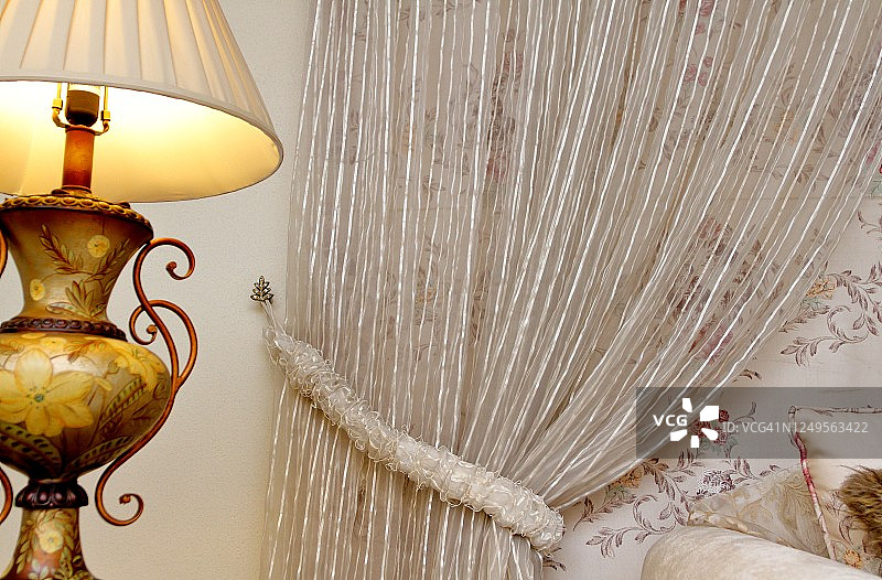 系着的窗帘、墙壁和点亮的电灯图片素材