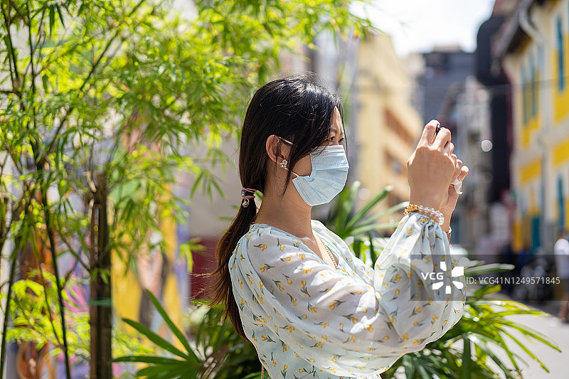 中国亚洲女子用智能手机拍摄街景图片素材