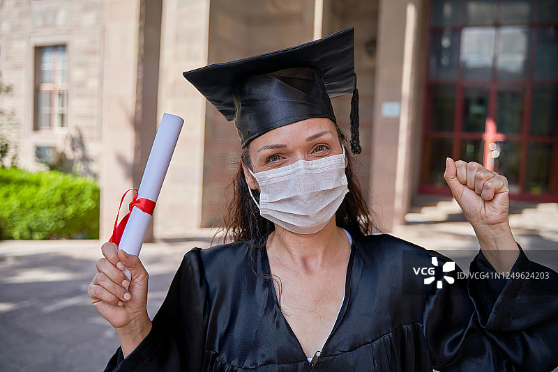 戴着医用口罩的毕业女学生图片素材