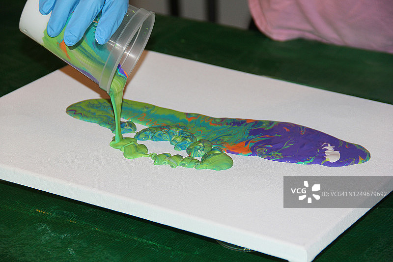 艺术家在画布上倒颜料特写图片素材