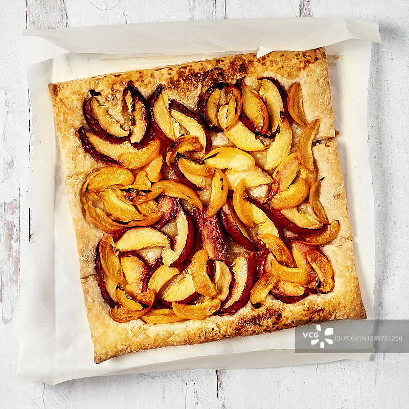 白色木质背景羊皮纸上的桃子馅饼图片素材