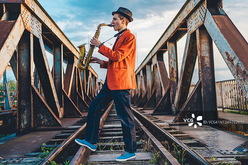 在铁路桥上吹萨克斯的男人图片素材
