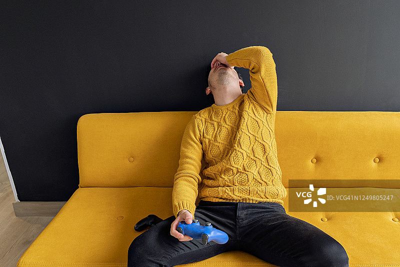 疫情隔离期间在家玩电子游戏的男人图片素材