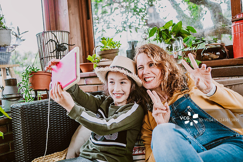 母亲和女儿在户外用平板电脑自拍图片素材