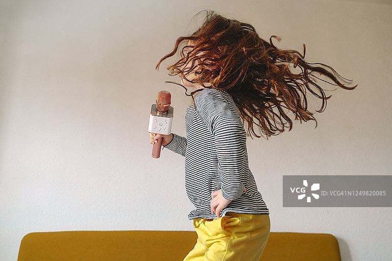 在床上跳跃唱歌的女孩图片素材