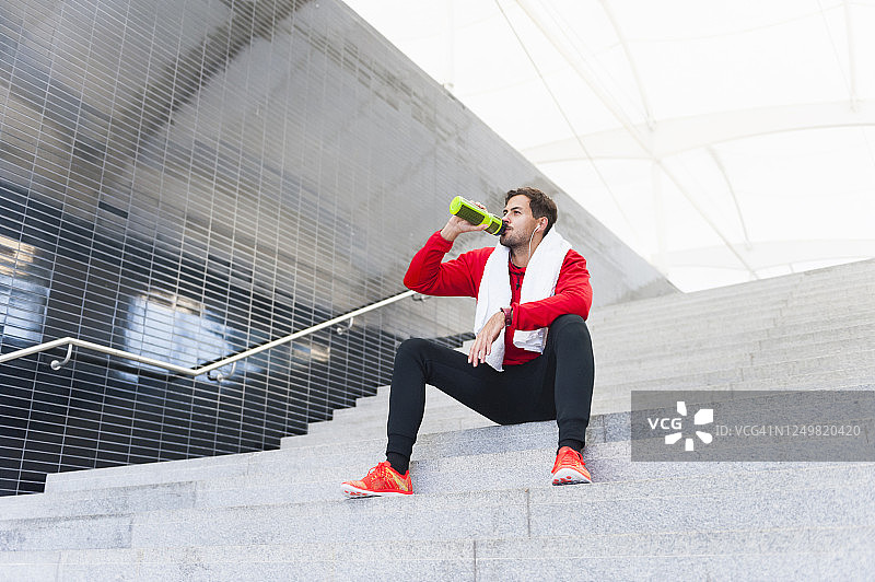 年轻男人锻炼后休息喝水图片素材