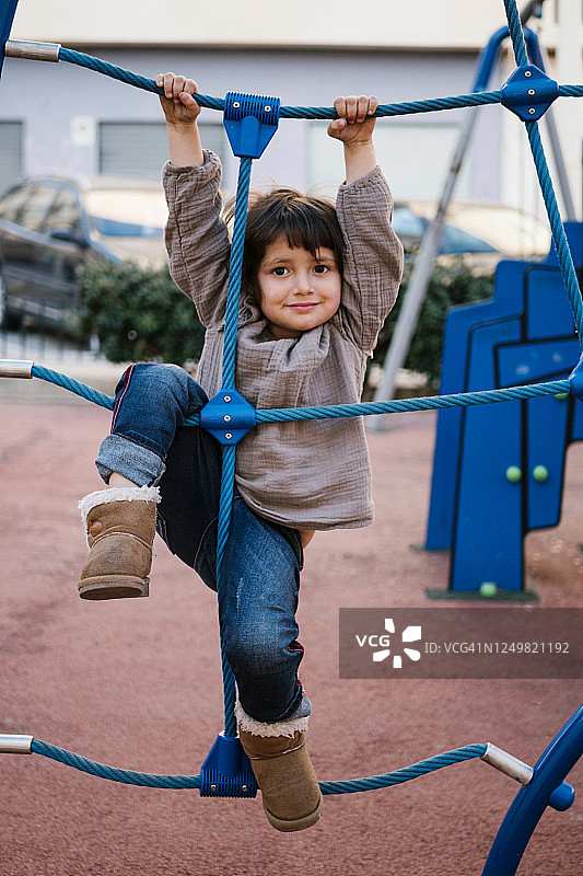 在游乐场攀爬网上的女孩图片素材