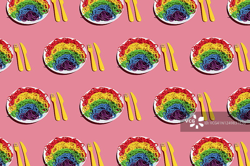 粉色背景上的彩虹色意大利面餐盘图案图片素材