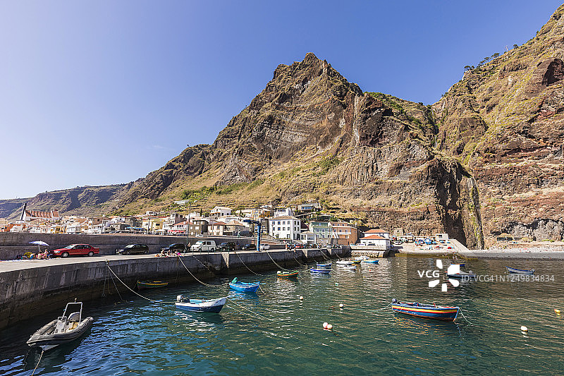 葡萄牙马德拉岛保罗·马尔港口停泊的渔船，背景是山脉和城镇图片素材