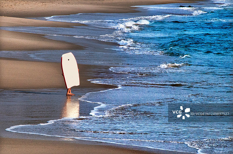 男孩在海滩上玩趴板图片素材