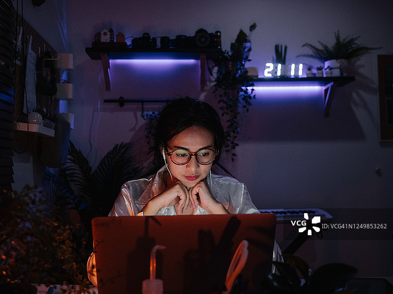 女员工在家用笔记本电脑努力工作到深夜。商务人士加班。图片素材