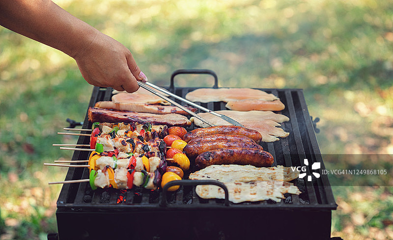 年轻女人在后院准备烧烤图片素材