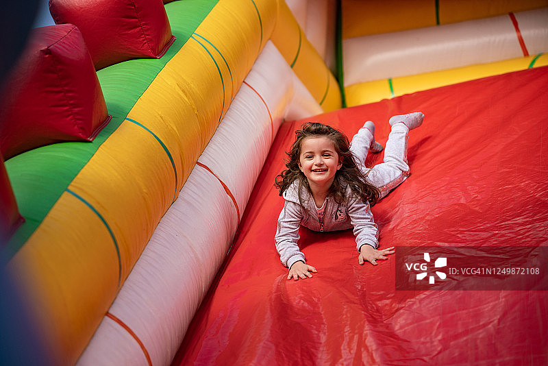 可爱的小女孩在充气城堡里玩耍图片素材