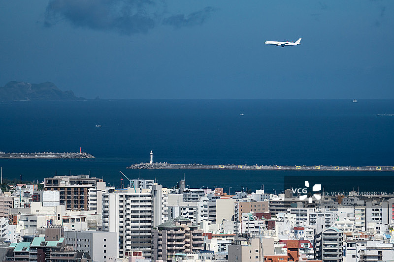 飞越冲绳县那霸市上空的飞机图片素材