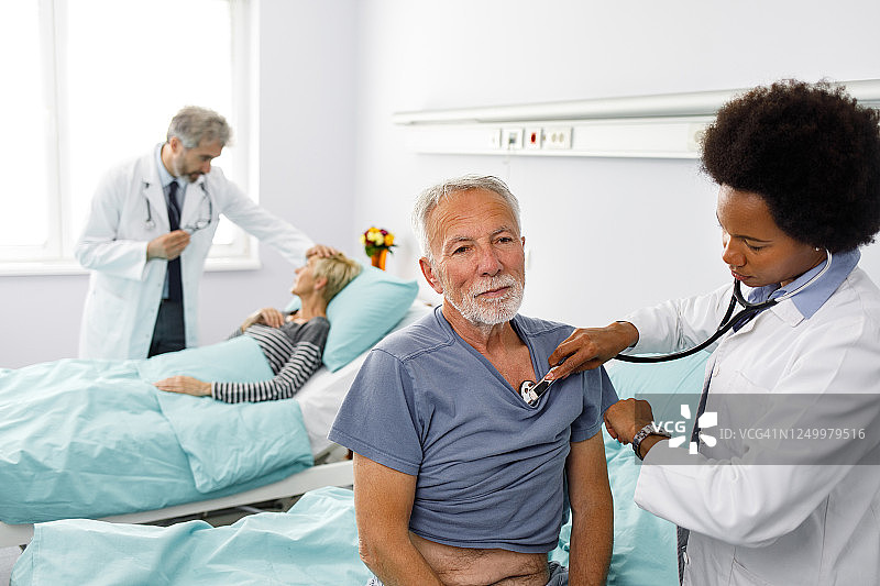 女医生用听诊器检查老年男病人图片素材