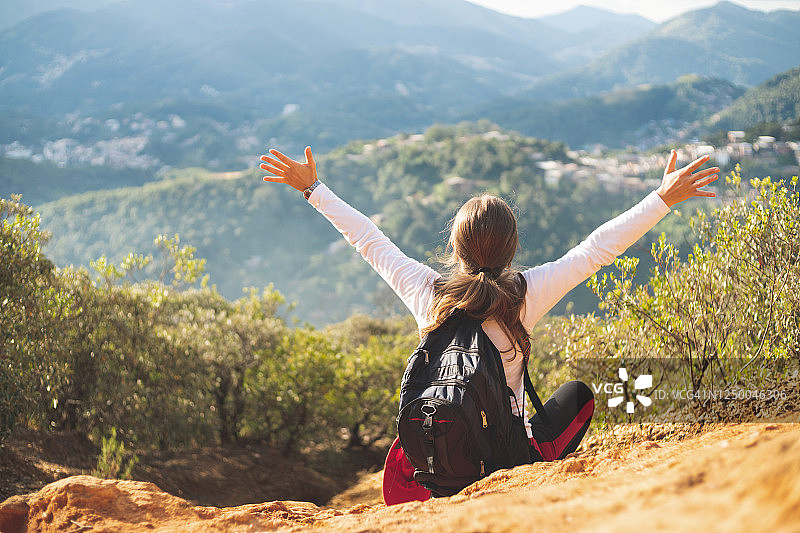 站在山顶举起双臂的女人背影图片素材