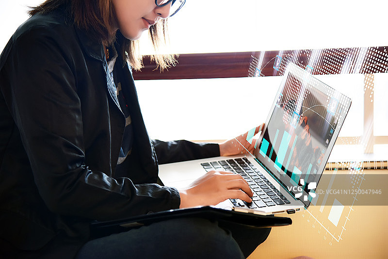 成功的亚洲女商人居家使用笔记本电脑，未来感抬头显示器界面，保持社交距离图片素材