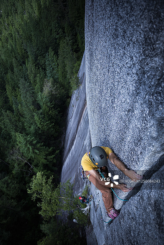 男人躺在斯阔米什花岗岩地面上的宽大裂缝中图片素材