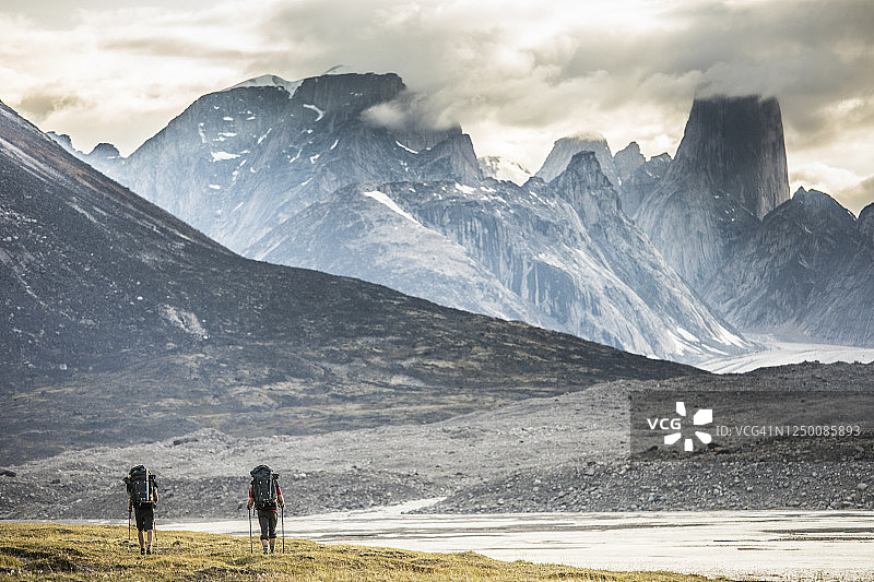 两个背包客徒步前往巴芬岛阿斯加德山图片素材