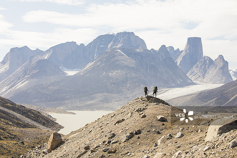 两名徒步旅行者站在阿克夏雅克山口巴芬岛的高山山脊上图片素材