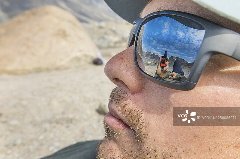 背包客太阳镜中GPS和山景的倒影图片素材