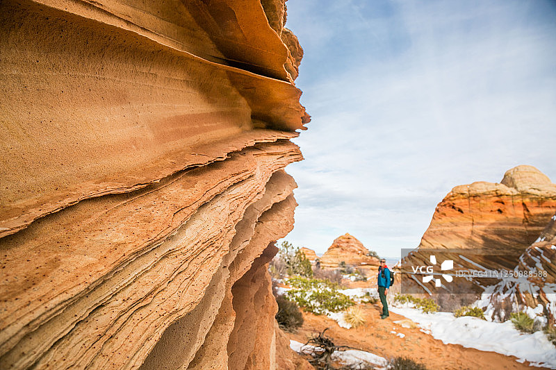 朱红悬崖的砂岩花边岩石与登山者图片素材