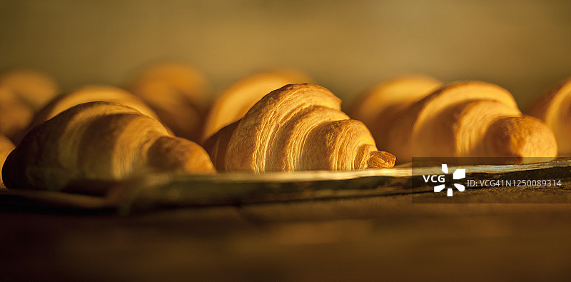 面包店烤箱中烘烤的可颂面包图片素材