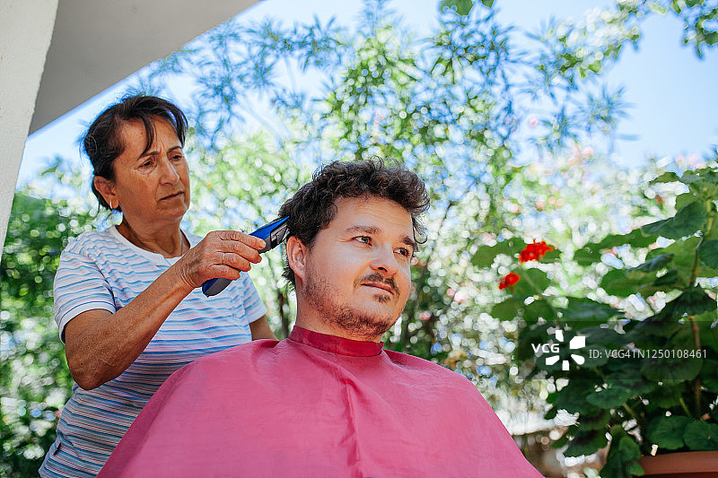 在家给儿子剪头发的女人图片素材