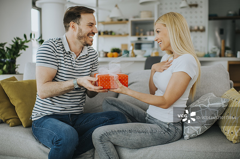 年轻浪漫情侣拿着礼物图片素材