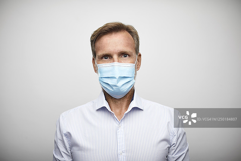 戴外科口罩的英俊中年商人图片素材