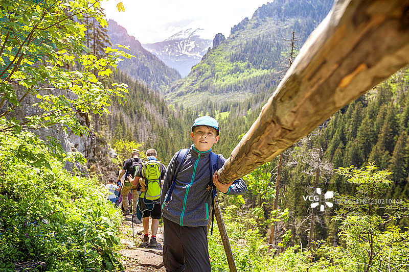 快乐的男孩在夏季旅行中登山图片素材